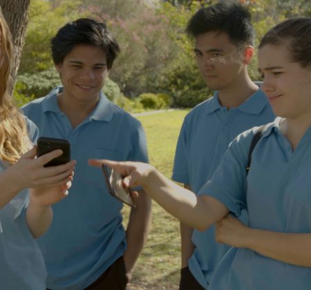 students gathering around a phone