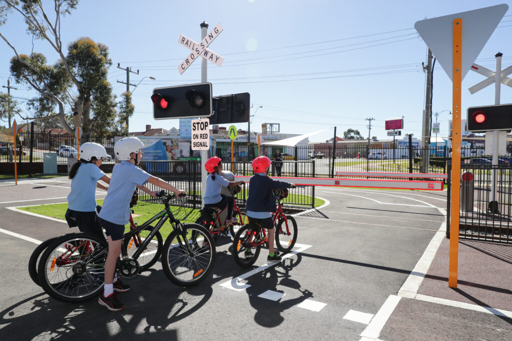 children waiting to cross road on bike