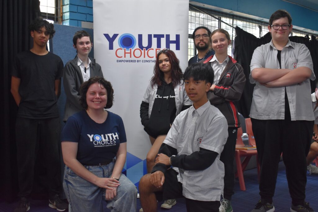 students in front of youth choice banner