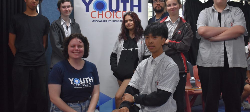 students in front of youth choice banner