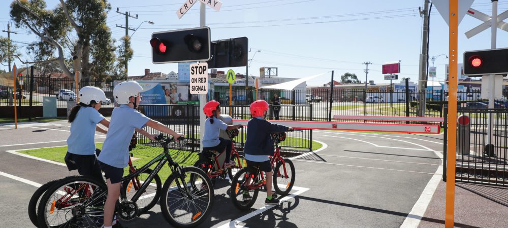 children waiting to cross road on bike